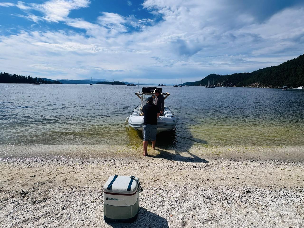 mike and boris negotiating with a boat on the shell beach