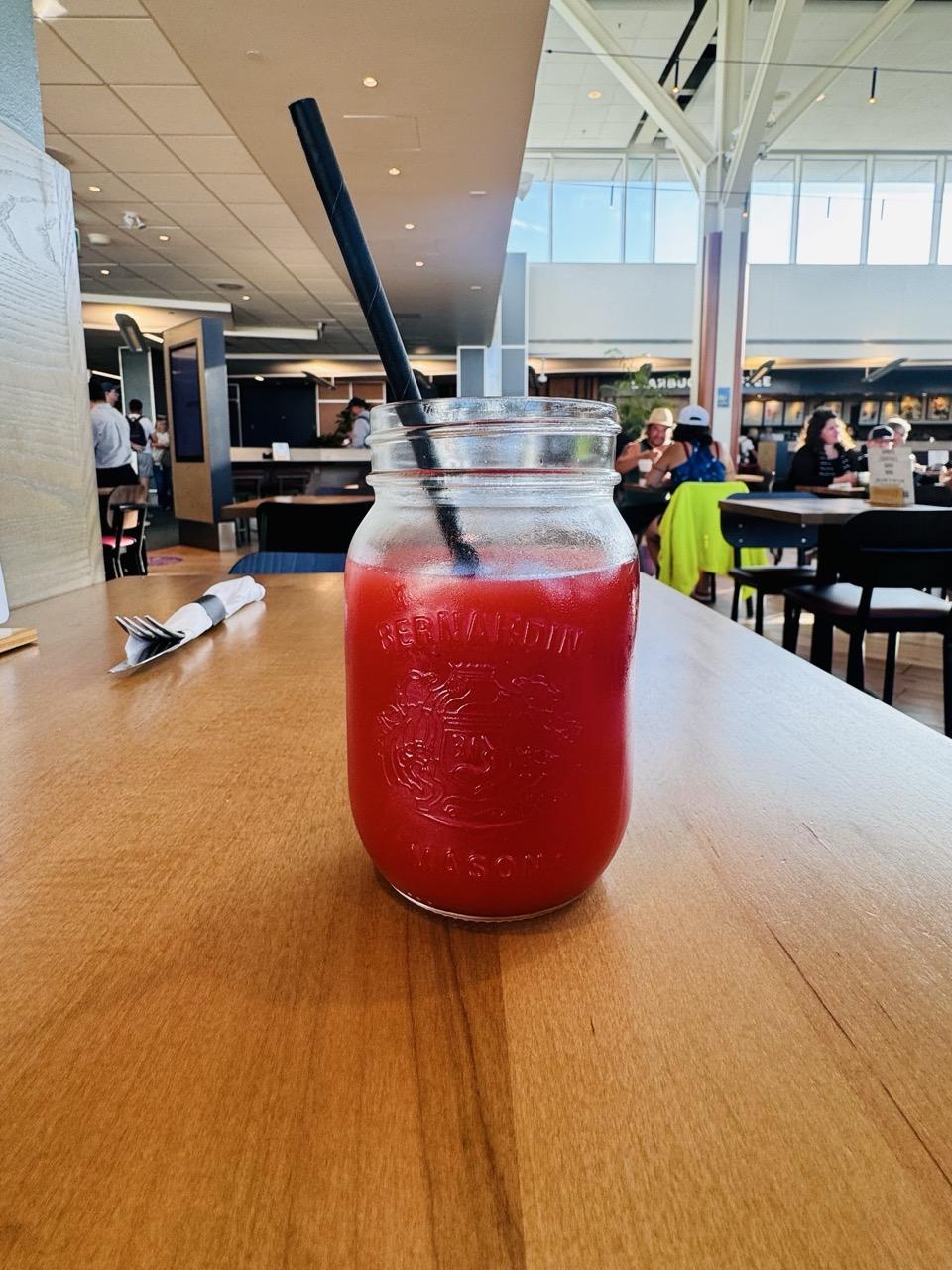 a glass of clamato with a straw