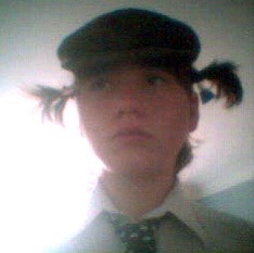 me as a teenager with pigtails, with a sad gay expression. the picture is low quality, like that of a cheap webcam