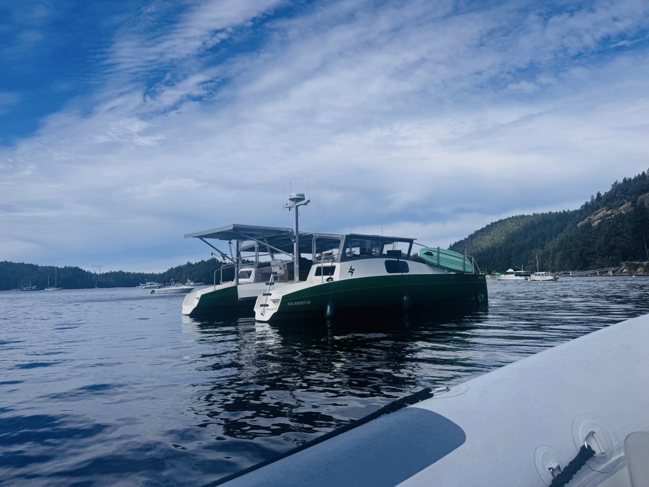 the solar catamaran, green and white, floating on the water looking handsome