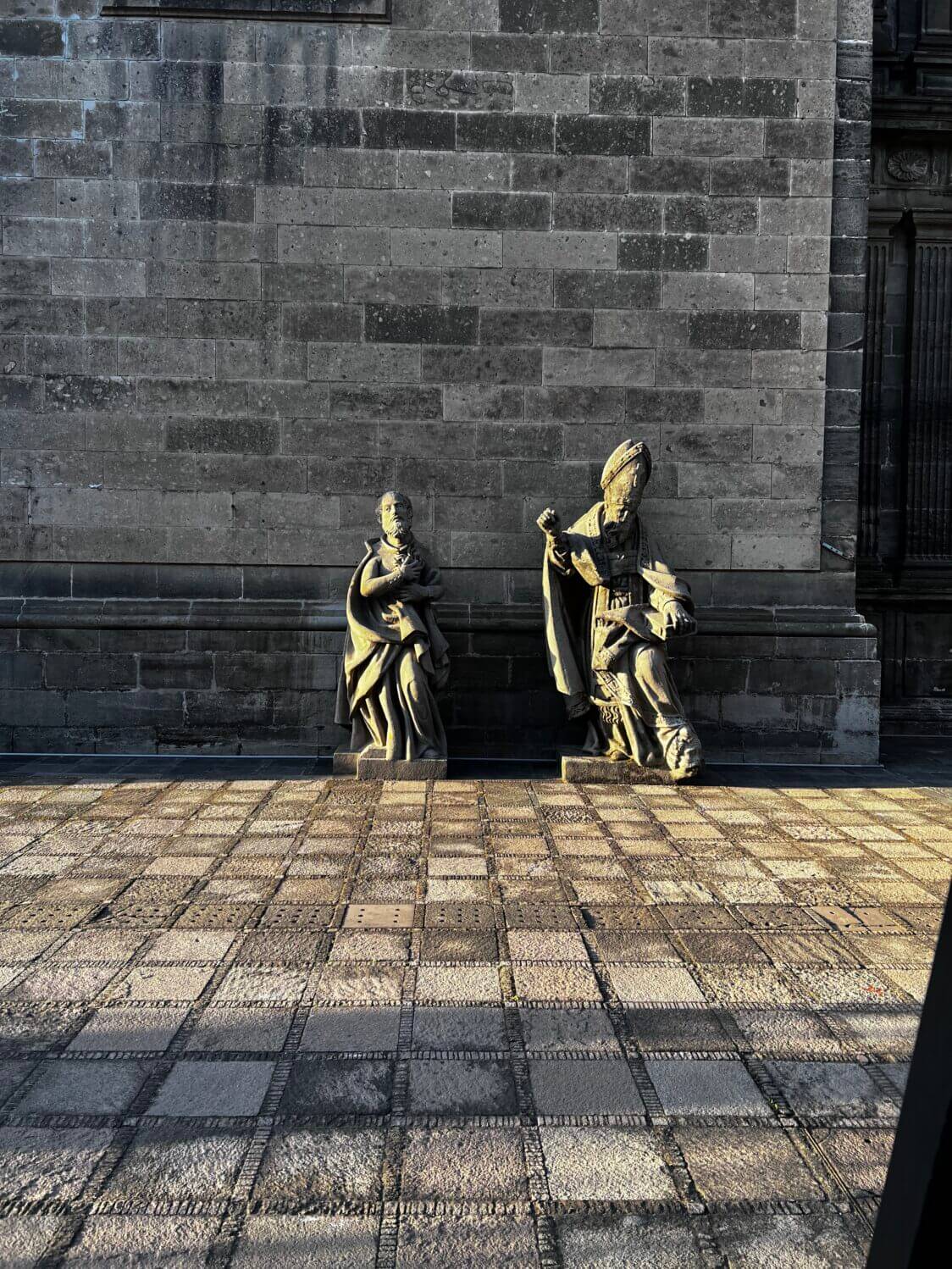 two statues outside a church that appear to be
dancing