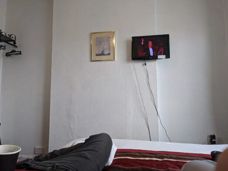 a small tv and a framed painting of
flowers on a white wall